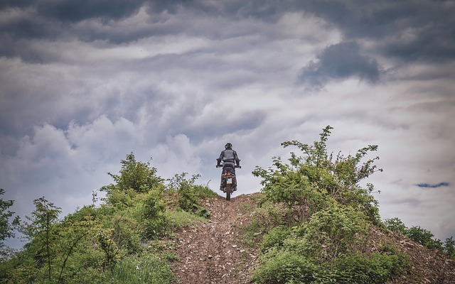 Muž na motorke, jazdí na kopci v prírode.jpg